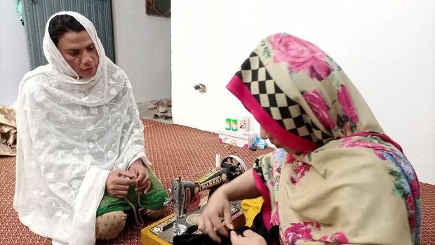 Rani Khan, a transgender woman who teaches the Koran at Pakistan's first transgender only madrasa or a religious school, looks at one of her students during a tailoring lesson in Islamabad, Pakistan March 10, 2021. Picture taken March 10, 2021. REUTERS/Salahuddin NO RESALES. NO ARCHIVES
