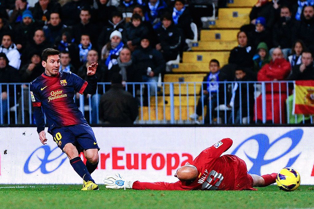 MALAGA, SPAIN - JANUARY 13:  Lionel Messi of FC Barcelona scores the opening goal as Willy Caballero of Malaga CF attempts to save during the La Liga match between Malaga CF and FC Barcelona at La Rosaleda Stadium on January 13, 2013 in Malaga, Spain.  (Photo by David Ramos/Getty Images)