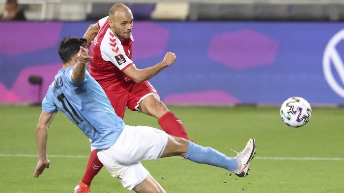 Denmarks Martin Braithwaite shoots by Israels Hatem Elhamed during the World Cup 2022 group F qualifying soccer match between Israel and Denmark in Tel Aviv, Israel, Thursday, March 25, 2021. (AP Photo/Ariel Schalit)