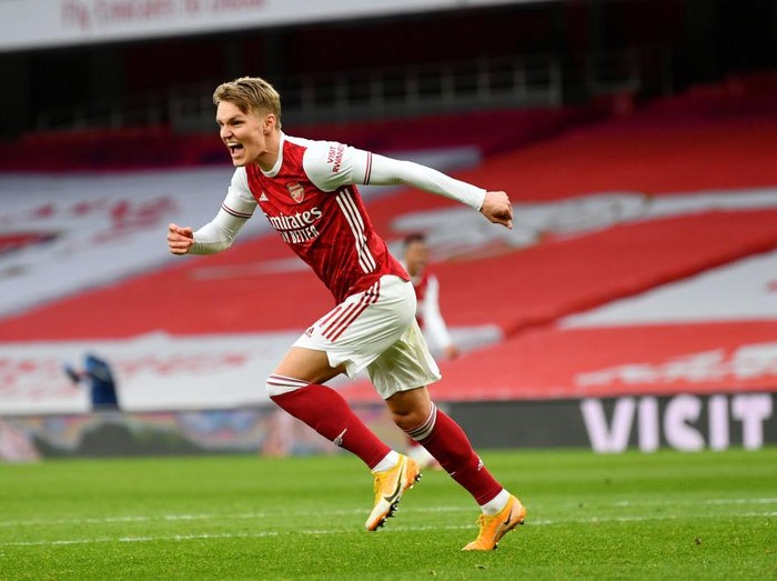 LONDON, ENGLAND - MARCH 14: Martin Odegaard of Arsenal celebrates after scoring their side's first goal during the Premier League match between Arsenal and Tottenham Hotspur at Emirates Stadium on March 14, 2021 in London, England. Sporting stadiums around the UK remain under strict restrictions due to the Coronavirus Pandemic as Government social distancing laws prohibit fans inside venues resulting in games being played behind closed doors. (Photo by Dan Mullan/Getty Images)