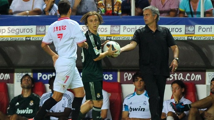 Real Madrids coach Jose Mourinho (R) gives the ball to Real Madrids Luka Modric (C) during the Spanish league football match between Sevilla FC and Real Madrid on September 15, 2012 at the Ramon Sanchez Pizjuan stadium in Sevilla. Real Madrid was defeated 1-0. AFP PHOTO/ JORGE GUERRERO (Photo by Jorge Guerrero / AFP)