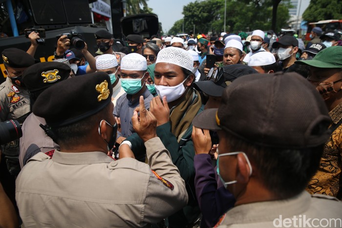 Polisi membubarkan dan menangkap para pendukung HRS yang berkerumun dan tidak mau membubarkan diri saat sidang berlangsung di PN Jakarta Timur, Jumat (26/3/2021).