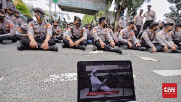 Petugas Kepolisian membubarkan massa pendukung saat berlangsungnya sidang tatap muka lanjutan kasus pelanggaran protokol kesehatan dengan terdakwa Rizieq Shihab di Pengadilan Negeri (PN) Jakarta Timur, Jakarta, Jumat, 26 Maret 2021. CNN Indonesia/Adhi Wicaksono