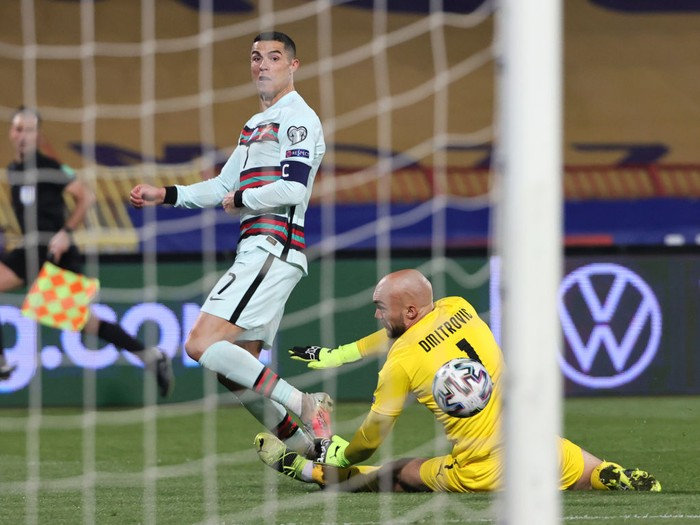 BELGRADE, SERBIA - MARCH 27: Cristiano Ronaldo of Portugal takes a shot under pressure from Marko Dmitrovic of Serbia  during the FIFA World Cup 2022 Qatar qualifying match between Serbia and Portugal at FK Crvena Zvezda stadium on March 27, 2021 in Belgrade, Serbia. Sporting stadiums around Serbia remain under strict restrictions due to the Coronavirus Pandemic as Government social distancing laws prohibit fans inside venues resulting in games being played behind closed doors.  (Photo by Srdjan Stevanovic/Getty Images)