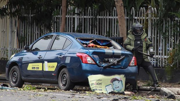 Ledakan di Gereja Katedral Makassar An Indonesian anti-bomb unit (C) collects evidences after a bomb exploded in Makassar on March 28, 2021. (Photo by IRVAN ABDULLAH / AFP)