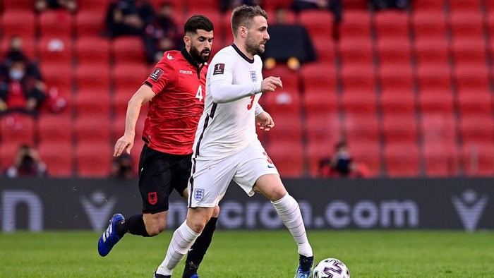 TIRANA, ALBANIA - MARCH 28: Luke Shaw of England runs with the ball whilst under pressure from Elseid Hysaj of Albania during the FIFA World Cup 2022 Qatar qualifying match between Albania and England at the Qemal Stafa Stadium on March 28, 2021 in Tirana, Albania. Sporting stadiums around Europe remain under strict restrictions due to the Coronavirus Pandemic as Government social distancing laws prohibit fans inside venues resulting in games being played behind closed doors.  (Photo by Mattia Ozbot/Getty Images)