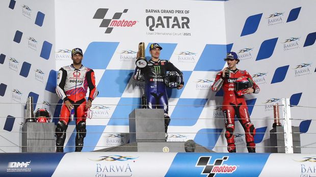 Monster Energy Yamaha MotoGP's Spanish rider Maverick Vinales (C), Pramac Racing's French rider Johann Zarco (L) and Ducati Lenovo Team's Italian rider Francesco Bagnaia celebrate the Moto GP Qatar Grand Prix at the Losail International Circuit, in the city of Lusail on March 28, 2021. - Yamaha's Vinales won the race, with Zarco and Bagnaia finishing second and third respectively. (Photo by KARIM JAAFAR / AFP)