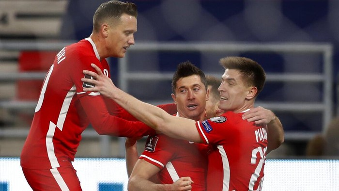 Polands Robert Lewandowski, centre, celebrates with team mates after scoring his sides third goal during the World Cup 2022 group I qualifying soccer match between Hungary and Poland at the Puskas Arena in Budapest, Hungry Thursday March 25, 2021. (AP Photo/Laszlo Balogh)