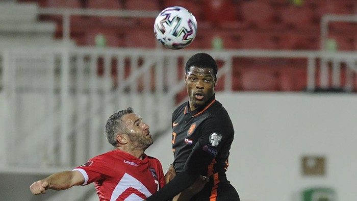 Denzel Dumfries of the Netherlands, right, heads the ball during the World Cup group G qualifying soccer match between Gibraltar and The Netherlands at the Victoria Stadium, Gibraltar, Tuesday March 30, 2021. (AP Photo/Ian Martinez)