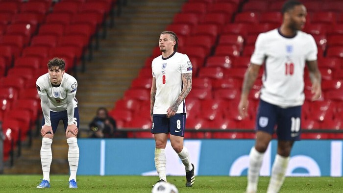 Englands John Stones, left, Kalvin Phillips, centre and Raheem Sterling react after Poland scored their first goal during the World Cup 2022 Group I qualifying soccer match between England and Poland at Wembley Stadium in London, England, Wednesday March 31, 2021. (Andy Rain/Pool via AP)