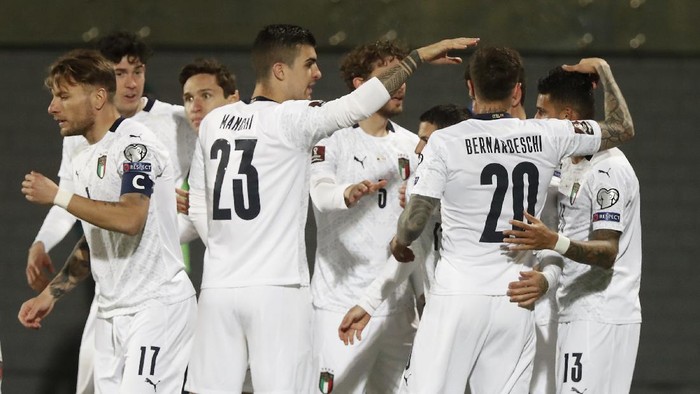 Italys Stefano Sensi, covered by his teammates, celebrates after scoring his sides opening goal during the World Cup 2022 Group C qualifying soccer match between Lithuania and Italy at LFF stadium in Vilnius, Wednesday, March 31, 2021. (AP Photo/Mindaugas Kulbis)