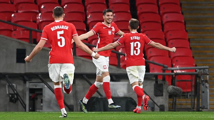 LONDON, ENGLAND - MARCH 31: Jakub Moder of Poland celebrates with Maciej Rybus after scoring their sides first goal during the FIFA World Cup 2022 Qatar qualifying match between England and Poland on March 31, 2021 at Wembley Stadium in London, England. Sporting stadiums around the UK remain under strict restrictions due to the Coronavirus Pandemic as Government social distancing laws prohibit fans inside venues resulting in games being played behind closed doors. (Photo by Andy Rain - Pool/Getty Images)