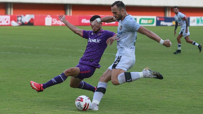 Pesepak bola Bali United Ilija Spasojevic (kanan) mencoba melewati pesepak bola Persita Tangerang Kevin Gomes (kiri) saat pertandingan Piala  Menpora 2021, di Stadion Maguwoharjo, Sleman, DI Yogyakarta, Jumat (2/4/2021). Pertandingan tersebut berakhir dengan skor 1-1 dan Bali United dipastikan lolos ke babak delapan besar. ANTARA FOTO/Hendra Nurdiyansyah/hp.