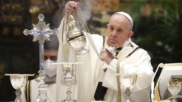 Pope Francis blows inside an amphora containing holy oil during a Chrism Mass inside St. Peter's Basilica, at the Vatican, Thursday, April 1, 2021. During the Mass the Pontiff blesses a token amount of oil that will be used to administer the sacraments for the year. (AP Photo/Andrew Medichini, pool)