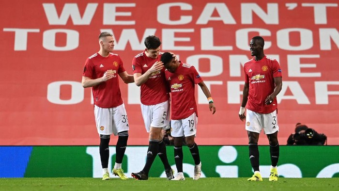 MANCHESTER, ENGLAND - MARCH 11: Amad Diallo of Manchester United celebrates with teammates Scott McTominay and Harry Maguire after scoring their teams first goal during the UEFA Europa League Round of 16 First Leg match between Manchester United and A.C. Milan at Old Trafford on March 11, 2021 in Manchester, England. Sporting stadiums around the UK remain under strict restrictions due to the Coronavirus Pandemic as Government social distancing laws prohibit fans inside venues resulting in games being played behind closed doors. (Photo by Laurence Griffiths/Getty Images)