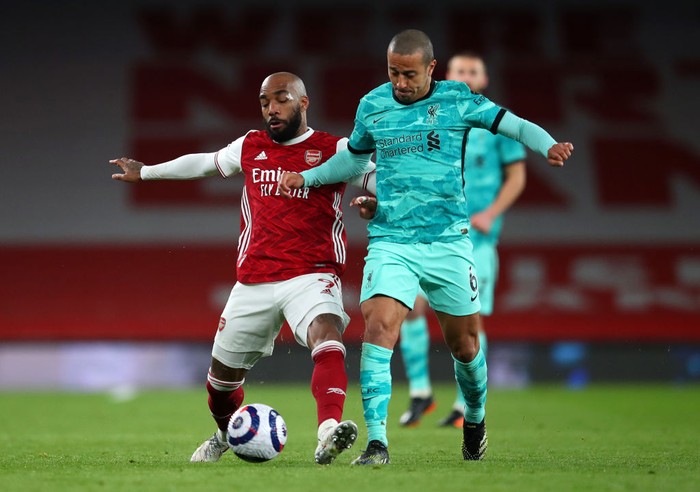 LONDON, ENGLAND - APRIL 03: Alexandre Lacazette of Arsenal  battles for possession with Thiago Alcantara of Liverpool during the Premier League match between Arsenal and Liverpool at Emirates Stadium on April 03, 2021 in London, England. Sporting stadiums around the UK remain under strict restrictions due to the Coronavirus Pandemic as Government social distancing laws prohibit fans inside venues resulting in games being played behind closed doors. (Photo by Catherine Ivill/Getty Images)