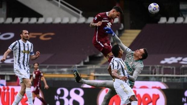 Torino's Paraguayan forward Antonio Sanabria (Top) shoots a header to score an equalizer past Juventus' Polish goalkeeper Wojciech Szczesny (R) during the Italian Serie A football match Torino vs Juventus on April 03, 2021 at the Olympic stadium in Turin. (Photo by Marco BERTORELLO / AFP)