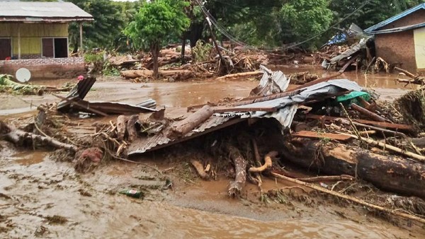 People walk amid debris at a village affected by flood in Ile Ape, on Lembata Island, East Nusa Tenggara province, Indonesia, Sunday, April 4, 2021 photo. Multiple disasters caused by torrential rains in eastern Indonesia have left dozens of people dead or missing while displacing thousands, the countrys disaster relief agency said Monday.