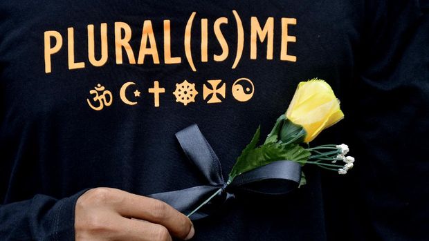ILUSTRASI PLURALISME Peserta aksi yang tergabung dalam Forum Rakyat Bersatu memegang bunga saat melakukan aksi solidaritas di depan Gereja Katedral, Makassar, Sulawesi Selatan, Minggu (4/4/2021). Aksi yang digelar dari berbagai elemen mahasiswa, tokoh agama, serta masyarakat tersebut sebagai aksi solidaritas kerukunan beragama guna mengajak seluruh masyarakat Indonesia untuk tetap solid dan mendeklarasikan diri untuk melawan aksi terorisme. ANTARA FOTO/Abriawan Abhe/foc.