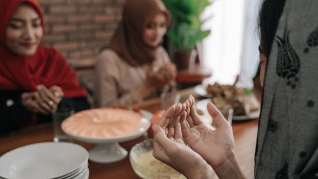 gesture of hand muslim praying in dining room before eating or break fasting