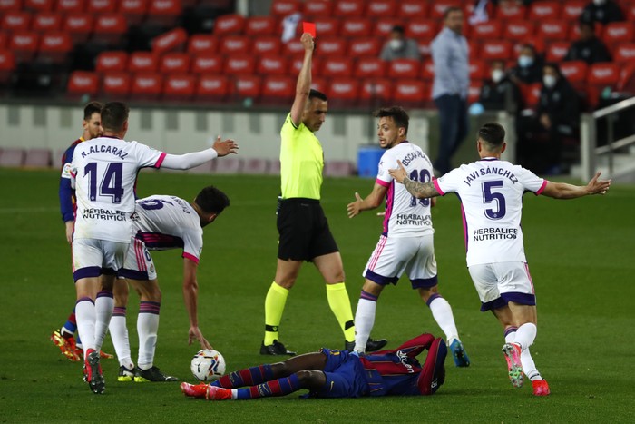 Referee Santiago Jaime Latre shows a red card to Valladolids Oscar Plano after he tackled Barcelonas Ousmane Dembele during the Spanish La Liga soccer match between FC Barcelona and Valladolid CF at the Camp Nou stadium in Barcelona, Spain, Monday, April 5, 2021. (AP Photo/Joan Monfort)