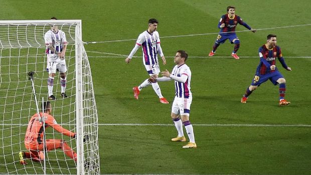 Soccer Football - La Liga Santander - FC Barcelona v Real Valladolid - Camp Nou, Barcelona, Spain - April 5, 2021 Barcelona's Lionel Messi and Riqui Puig celebrate after Ousmane Dembele scored their first goal while Real Valladolid players look dejected REUTERS/Albert Gea