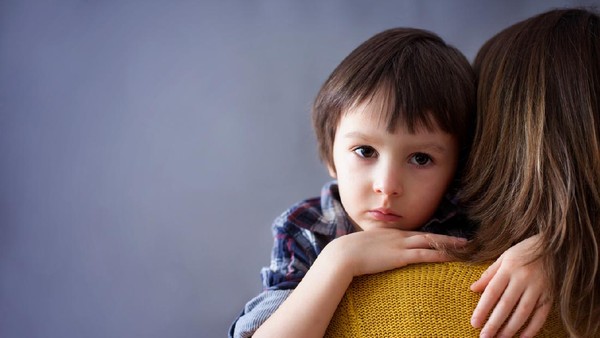 Sad little child, boy, hugging his mother at home, isolated image, copy space. Family concept