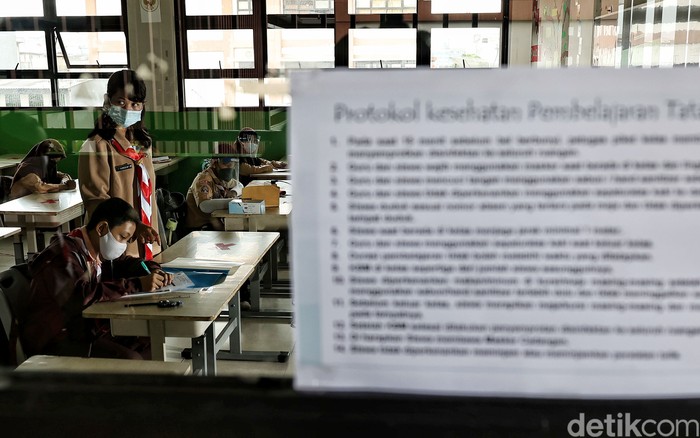 Guru memberikan pelajaran kepada murid saat uji coba belajar tatap muka di kawasan SDN 11 Pademangan Barat, Jakarta Utara, Rabu (7/4). SDN Pademangan Barat 11 memulai uji coba belajar tatap muka bagi siswa kelas V di tengah pandem COVID-19. Protokol kesehatan menjadi hal utama baik bagi siswa maupun tenaga pendidik.