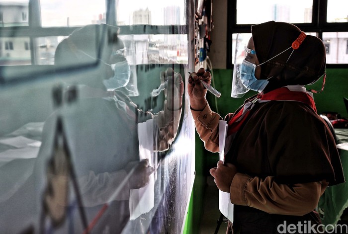 Melepaskan Kerinduan Belajar di Sekolah Guru memberikan pelajaran kepada murid saat uji coba belajar tatap muka di kawasan SDN 11 Pademangan Barat, Jakarta Utara, Rabu (7/4). SDN Pademangan Barat 11 memulai uji coba belajar tatap muka bagi siswa kelas V di tengah pandem COVID-19. Protokol kesehatan menjadi hal utama baik bagi siswa maupun tenaga pendidik.