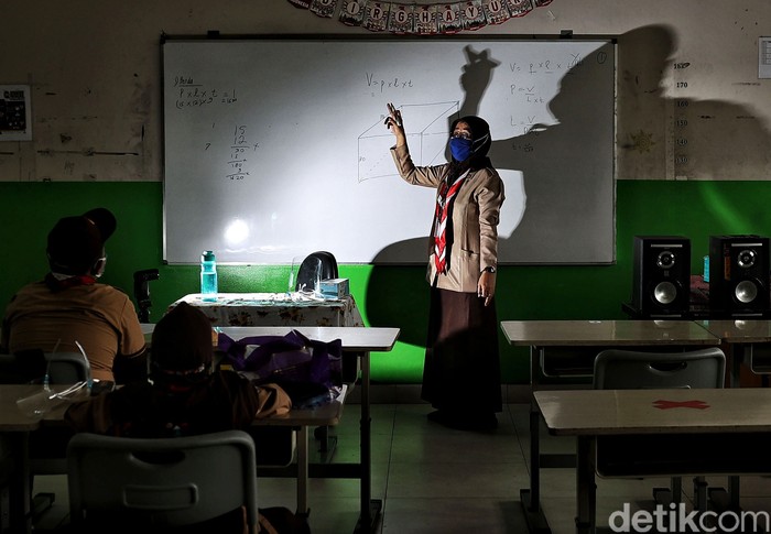 Guru memberikan pelajaran kepada murid saat uji coba belajar tatap muka di kawasan SDN 11 Pademangan Barat, Jakarta Utara, Rabu (7/4). SDN Pademangan Barat 11 memulai uji coba belajar tatap muka bagi siswa kelas V di tengah pandem COVID-19. Protokol kesehatan menjadi hal utama baik bagi siswa maupun tenaga pendidik.