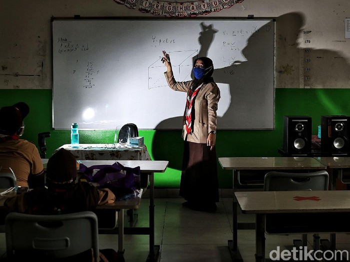 Guru memberikan pelajaran kepada murid saat uji coba belajar tatap muka di kawasan SDN 11 Pademangan Barat, Jakarta Utara, Rabu (7/4). SDN Pademangan Barat 11 memulai uji coba belajar tatap muka bagi siswa kelas V di tengah pandem COVID-19. Protokol kesehatan menjadi hal utama baik bagi siswa maupun tenaga pendidik.