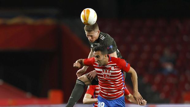 Manchester United's Scott McTominay, left, jumps for a header with Granada's Angel Montoro during the Europa League, quarterfinal, first leg soccer match between Granada and Manchester United at the Los Carmenes stadium in Granada, Spain, Thursday, April 8, 2021. (AP Photo/Fermin Rodriguez)