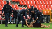 Tak pakai lama, pria bugil itu langsung dikepung petuugas pertandingan Granada vs MU. (Foto: Cristina Quicler/AFP/Edit)