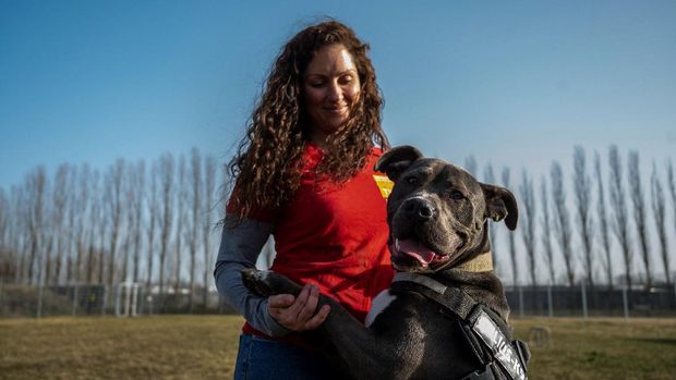 Xenia Katzurke, behavioral therapist for dogs at the Tierheim Berlin animal shelter, holds an American Staffordshire Terrier Mix called Marti, as she speaks to reporters on the grounds of the animal shelter in Berlin on February 23, 2021. - The sprawling complex in northeast Berlin, which houses domestic, as well as wild animals, was built in 2001, and counts as one of Europe's largest animal shelters. Germany has seen an explosion in pet adoption in the pandemic, with demand for cats, dogs and other furry companions soaring as people seek ways to ease loneliness and boredom. (Photo by John MACDOUGALL / AFP) / TO GO WITH AFP STORY BY FEMKE COLBORNE