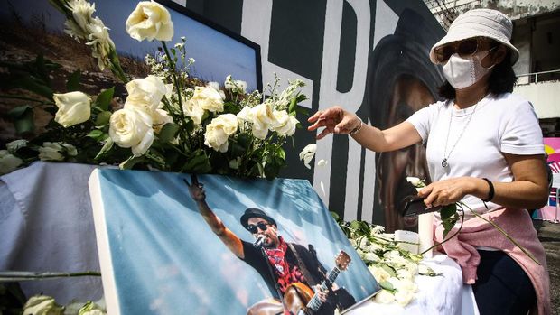 MENGENANG SATU TAHUN MENINGGALNYA GLENN FREDLY Penggemar meletakkan bunga di depan mural penyanyi almarhum Glenn Fredly dalam acara