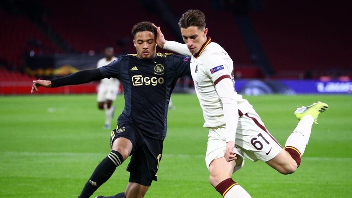 AMSTERDAM, NETHERLANDS - APRIL 08: Riccardo Calafiori of A.S Roma shoots whilst under pressure from Devyne Rensch of Ajax during the UEFA Europa League Quarter Final First Leg match between Ajax and AS Roma at Johan Cruijff Arena on April 08, 2021 in Amsterdam, Netherlands. Sporting stadiums around Europe remain under strict restrictions due to the Coronavirus Pandemic as Government social distancing laws prohibit fans inside venues resulting in games being played behind closed doors. (Photo by Dean Mouhtaropoulos/Getty Images)