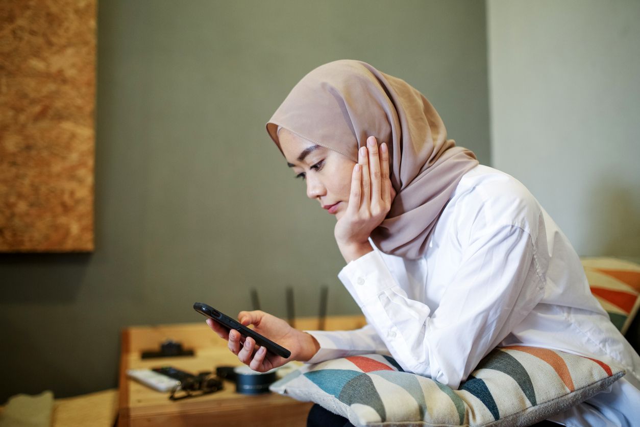 One women looking at the phone during eid celebration in Malaysia