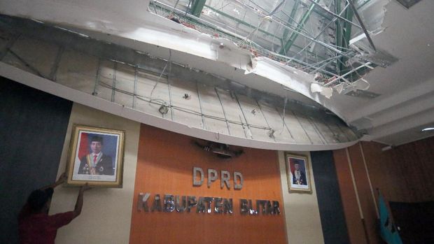 Petugas membersihkan puing-puing yang runtuh di Ruang Sidang Paripurna DPRD Kabupaten Blitar akibat gempa bumi di Blitar, Jawa Timur, Sabtu (19/4/2021). Akibat gempa tersebut, sejumlah rumah, gedung fasilitas umum, dan tempat ibadah di sekitar delapan kecamatan di wilayah Kota dan Kabupaten Blitar dilaporkan rusak. ANTARA FOTO/Irfan Anshori/aww.
