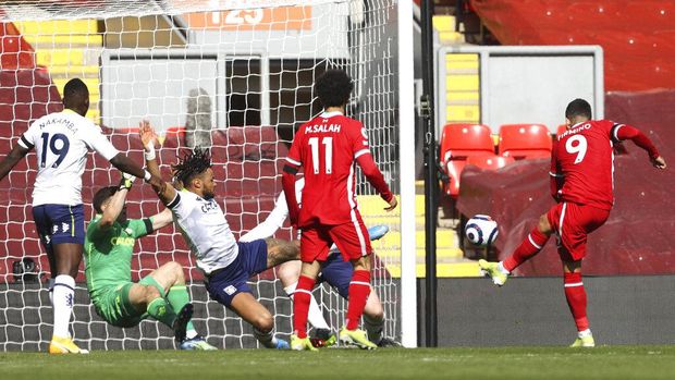 Liverpool's Roberto Firmino, right, scores, but following a VAR the goal is disallowed due to an earlier off-side, during the English Premier League soccer match between Liverpool and Aston Villa at Anfield stadium in Liverpool, England, Saturday, April 10, 2021. (Clive Brunskill/Pool via AP)