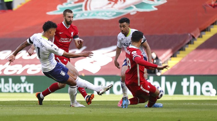 Aston Villas Ollie Watkins, left, scores his sides opening goal during the English Premier League soccer match between Liverpool and Aston Villa at Anfield stadium in Liverpool, England, Saturday, April 10, 2021. (Clive Brunskill/Pool via AP)