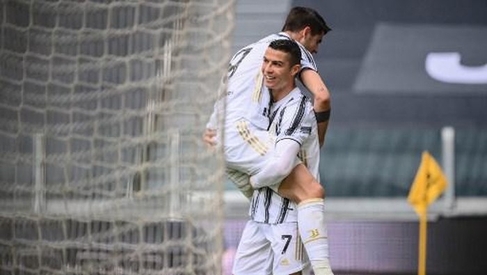 Juventus Portuguese forward Cristiano Ronaldo carries Juventus Spanish forward Alvaro Morata after Morata scorred the second goal during the Italian Serie A football match Juventus vs Genoa on April 11, 2021 at the Juventus stadium in Turin. (Photo by Marco BERTORELLO / AFP)