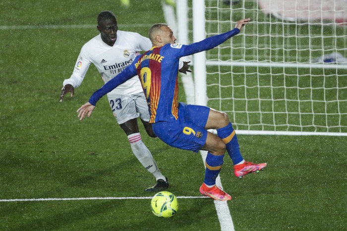 Barcelonas Martin Braithwaite, right, vies for the ball with Real Madrids Ferland Mendy during the Spanish La Liga soccer match between Real Madrid and FC Barcelona at the Alfredo di Stefano stadium in Madrid, Spain, Saturday, April 10, 2021. Real Madrid won 2-1. (AP Photo/Manu Fernandez)