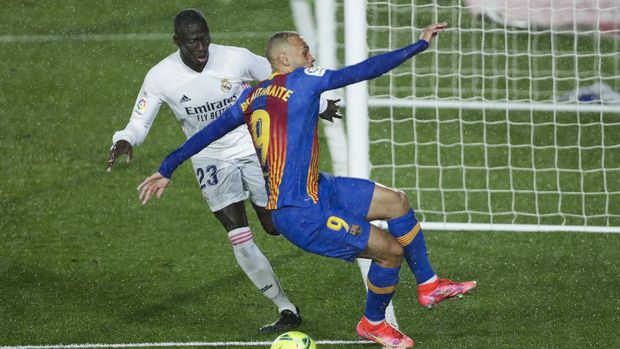 Barcelona's Martin Braithwaite, right, vies for the ball with Real Madrid's Ferland Mendy during the Spanish La Liga soccer match between Real Madrid and FC Barcelona at the Alfredo di Stefano stadium in Madrid, Spain, Saturday, April 10, 2021. Real Madrid won 2-1. (AP Photo/Manu Fernandez)