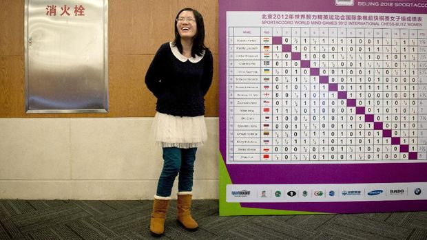 Chess player Hou Yifan of China stands beside a scoreboard following her win in a 'blinfold' chess tournament at the Beijing 2012 World Mind Games Tournament in Beijing on December 19, 2012. Some of the world's top chess players went eye-to-eye in the year's highest-level 