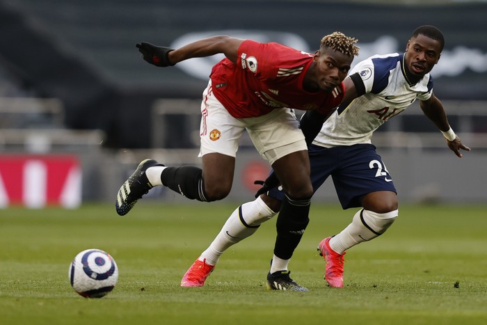 Tottenhams Serge Aurier, right, is challenged by Manchester Uniteds Paul Pogba during the English Premier League soccer match between Tottenham Hotspur and Manchester United at the Tottenham Hotspur Stadium in London, Sunday, April 11, 2021. (Adrian Dennis/Pool via AP)