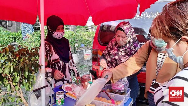 Sejumlah pedagang takjil sedang melayani pembeli di Jalan Bendungan Hilir (Benhil), Tanah Abang, Jakarta Pusat. Mereka mengeluhkan pengunjung yang sepi akibat bazar Pasar Benhil yang ditutup selama pandemi, Swlasa (14/3).