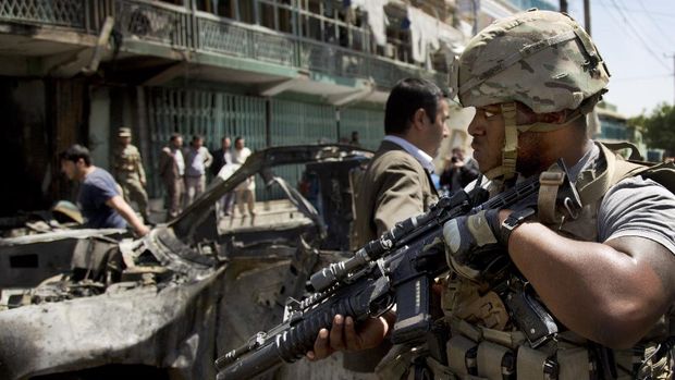 A U.S. soldier arrives at the scene where a suicide car bomber attacked a NATO convoy in Kabul, Afghanistan on May 16, 2013. A Muslim militant group, Hizb-e-Islami, claimed responsibility for the powerful explosion that killed and wounded many and rattled buildings across Kabul. (AP Photo/Anja Niedringhaus, File)