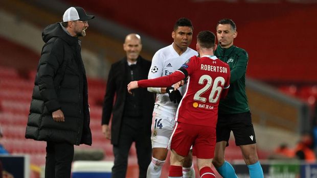 LIVERPOOL, ENGLAND - APRIL 14: Casemiro of Real Madrid clashes with Andrew Robertson of Liverpool during the UEFA Champions League Quarter Final Second Leg match between Liverpool FC and Real Madrid at Anfield on April 14, 2021 in Liverpool, England. Sporting stadiums around the UK remain under strict restrictions due to the Coronavirus Pandemic as Government social distancing laws prohibit fans inside venues resulting in games being played behind closed doors. (Photo by Shaun Botterill/Getty Images)