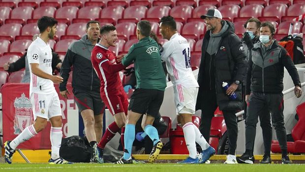 Liverpool's Andrew Robertson, center left, fights with Real Madrid's Casemiro during a Champions League quarter final second leg soccer match between Liverpool and Real Madrid at Anfield stadium in Liverpool, England, Wednesday, April 14, 2021. (AP Photo/Jon Super)