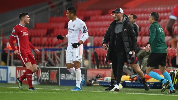 LIVERPOOL, ENGLAND - APRIL 14: Casemiro of Real Madrid clashes with Andrew Robertson of Liverpool as Jurgen Klopp (R), Manager of Liverpool reacts during the UEFA Champions League Quarter Final Second Leg match between Liverpool FC and Real Madrid at Anfield on April 14, 2021 in Liverpool, England. Sporting stadiums around the UK remain under strict restrictions due to the Coronavirus Pandemic as Government social distancing laws prohibit fans inside venues resulting in games being played behind closed doors. (Photo by Michael Regan/Getty Images)